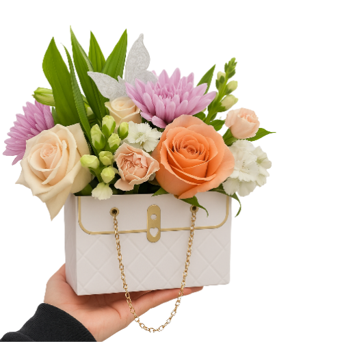 Arreglo floral en forma de bolso con rosas y flores en tonos suaves, presentado como regalo elegante en Bogotá.