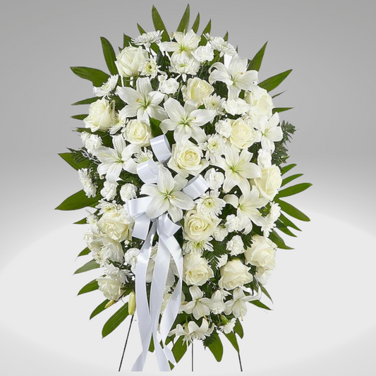 Cielo es un ramo fúnebre en rosas y lirios para expresar nuestro más sincero pésame, un deseo de paz y consuelo en medio de un momento de duelo (incluye cinta con nombre de remitente)