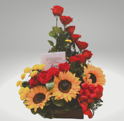 Arreglo floral con girasoles y rosas entregado como regalo alegre en un ambiente exterior en Bogotá.